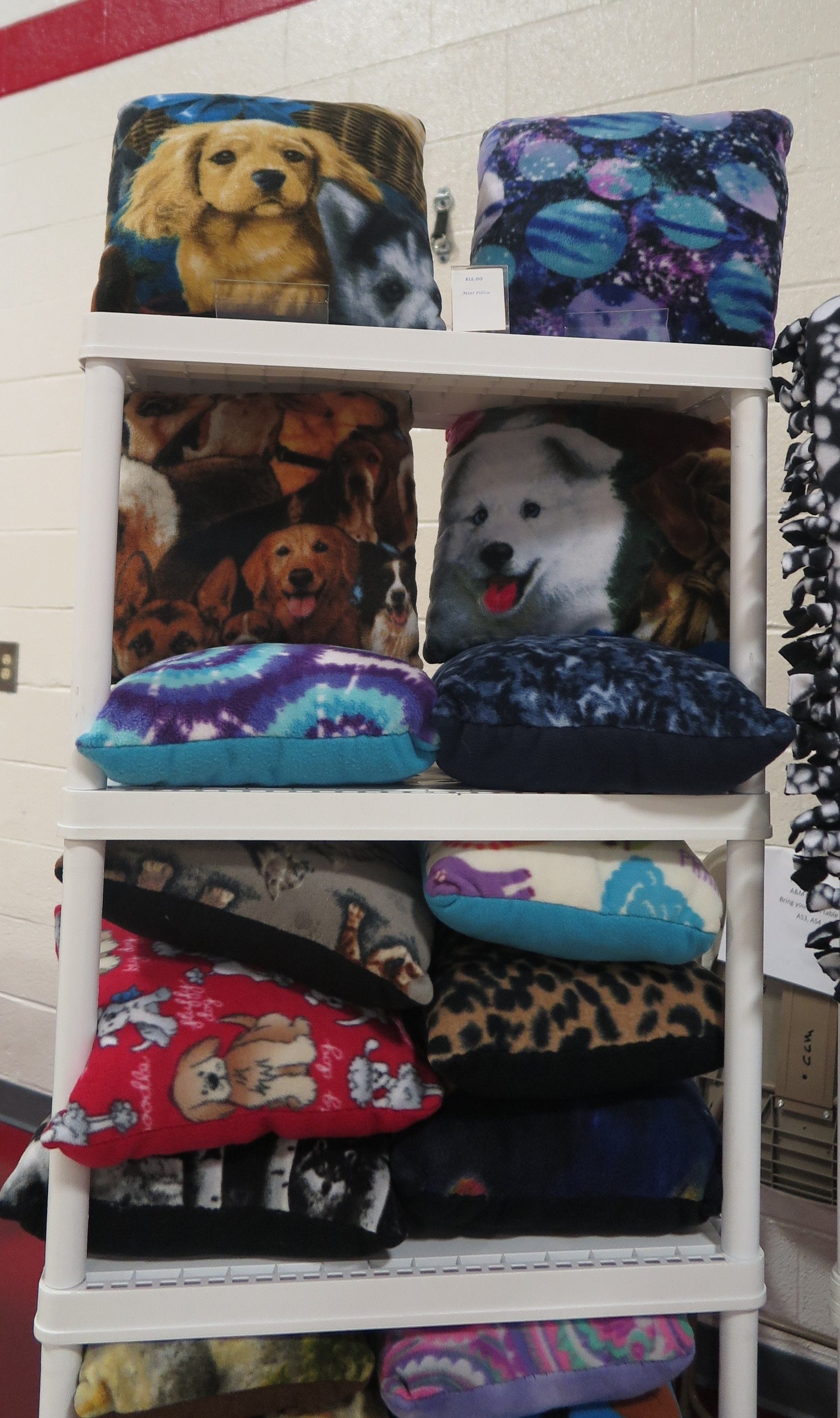 Handmade pillows featuring various patterns. Some dogs, a blue tie dye pattern, and an animal spot pattern can be seen.